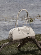 Songmont Yore Toast Bag Cloud - bag resting on driftwood beside water