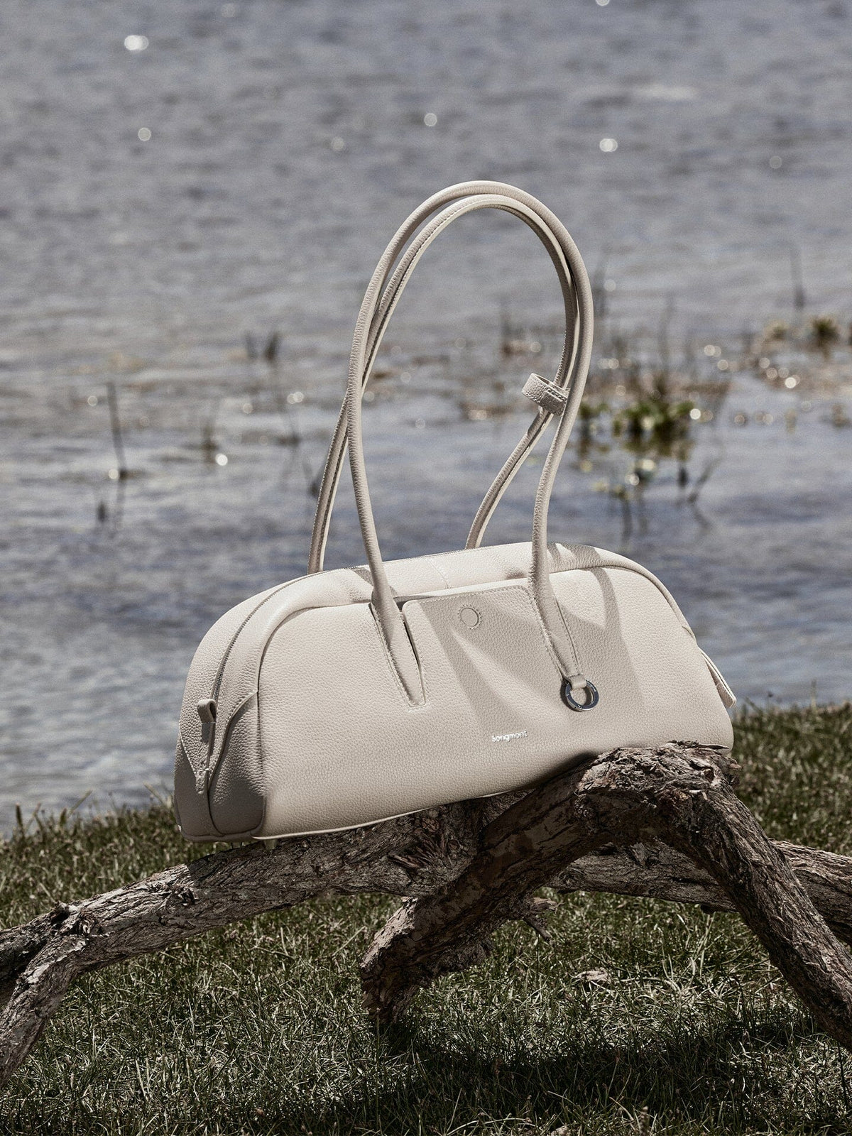 Songmont Yore Toast Bag Cloud - bag resting on driftwood beside water