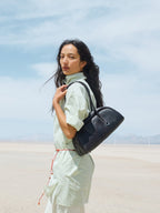 Songmont Yore Toast Bag Ebony - worn on the shoulder in a desert setting