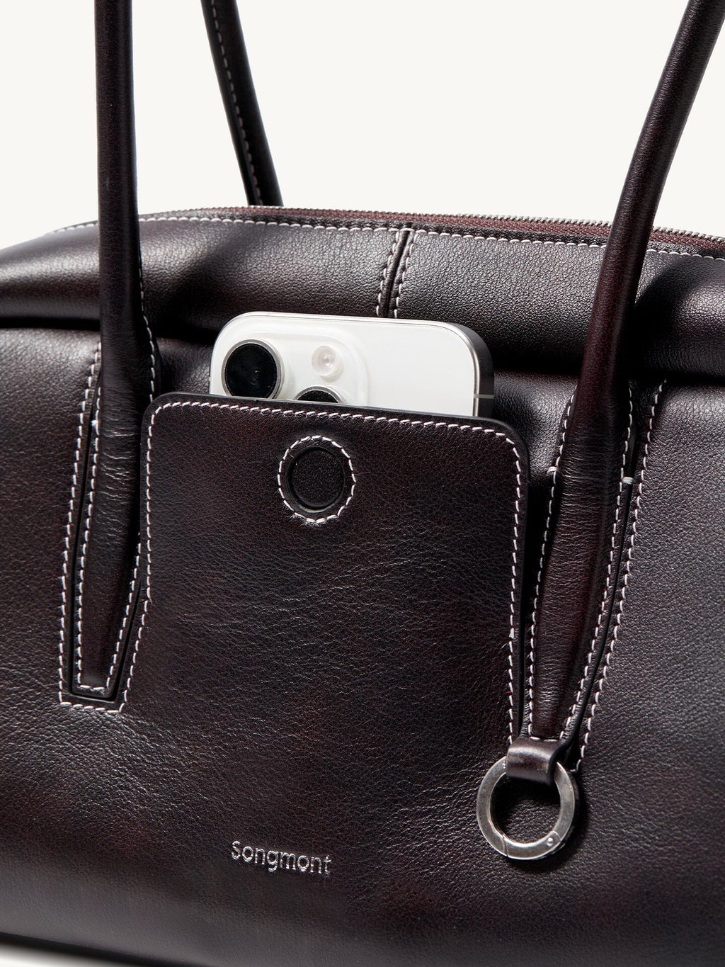Songmont Yore Toast Bag Ebony - front slip pocket holding a phone, metal ring detail