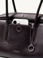 Songmont Yore Toast Bag Ebony - front slip pocket holding a phone, metal ring detail