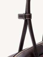 Songmont Yore Toast Bag Ebony - close-up of the leather keeper on the handles